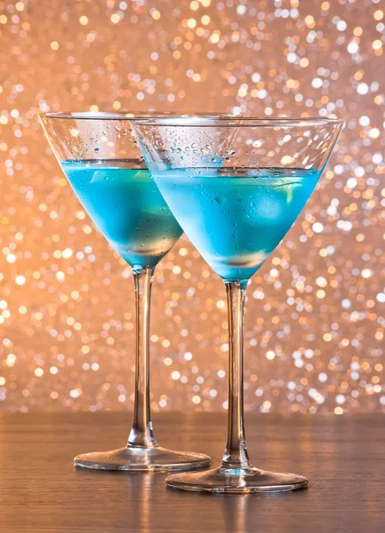 Glasses of fresh blue cocktail with ice on bar table — Stock Photo, Image