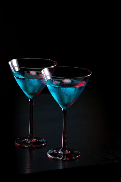 Glasses of fresh blue cocktail with ice on bar table — Stock Photo, Image