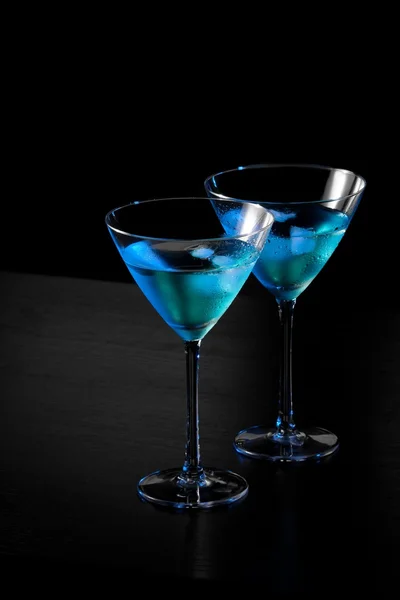 Glasses of fresh blue cocktail with ice on bar table — Stock Photo, Image