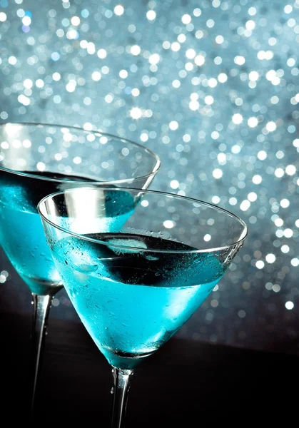 A pair of glasses of fresh blue cocktail with ice on bar table — Stock Photo, Image