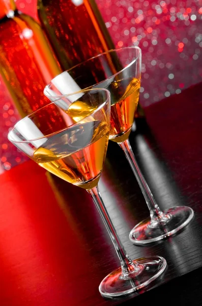 Glasses of cocktail on bar table in front of bottles — Stock Photo, Image