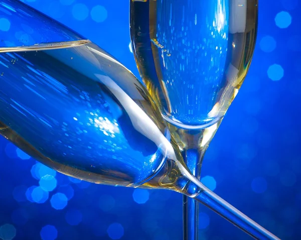 Champagne flöjter på blå ljus bokeh bakgrund — Stockfoto