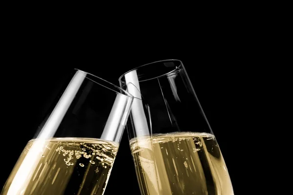 Una coppia di flauti champagne con bollicine dorate su fondo nero chiaro — Foto Stock