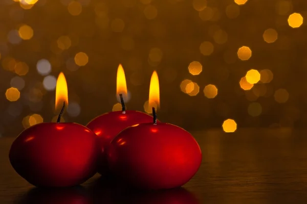 Červené svíčky na pozadí zlatých bokeh — Stock fotografie
