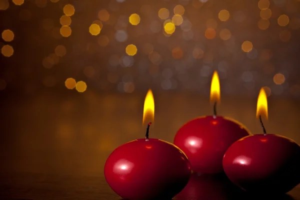 Velas de Natal vermelho no fundo dourado do bokeh — Fotografia de Stock