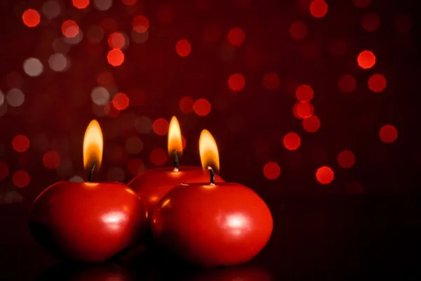 Velas de Natal vermelho no fundo vermelho do bokeh — Fotografia de Stock