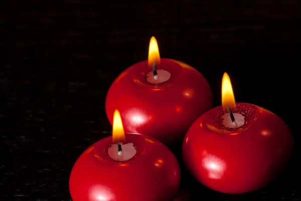 Top of view of red christmas candles on black wood table background — Stock Photo, Image