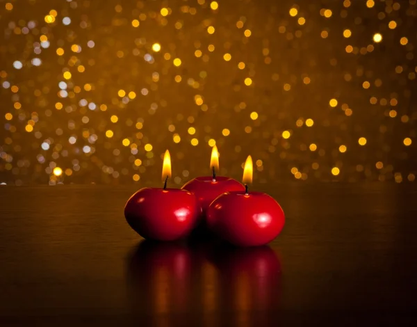 Rote Weihnachtskerzen auf Holztisch goldener Bokeh-Hintergrund — Stockfoto