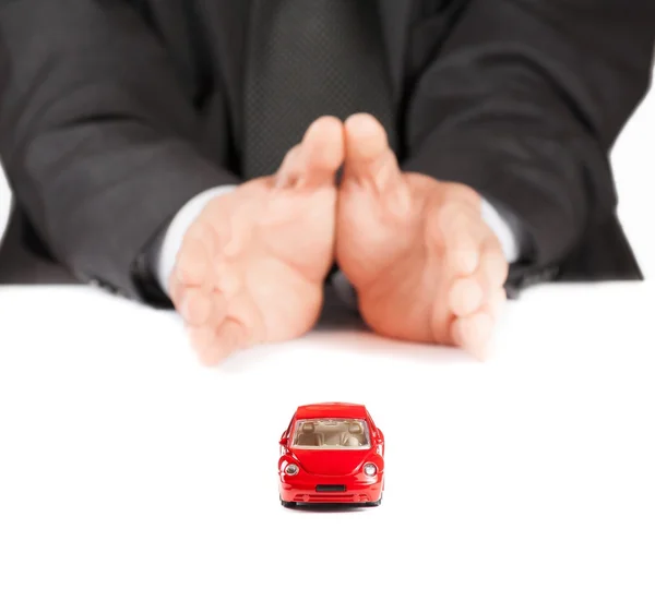 Carro de brinquedo vermelho na frente do empresário, conceito de seguro, compra, aluguel, combustível ou serviço e custos de reparação — Fotografia de Stock