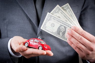oyuncak araba ve iş adamı kavramı sigorta satın alma, Kiralama, yakıt veya servis ve onarım maliyetleri, elinde dolar