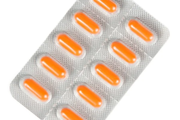 Haut de la vue de pilules orange emballées dans une plaquette isolée — Photo