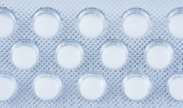 Tetejére nézet csomagolva fólia elszigetelt fehér tabletták — Stock Fotó