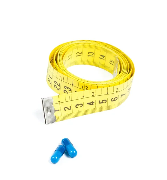 Medical blue pills in front of measure tape, concept for diet — Stock Photo, Image