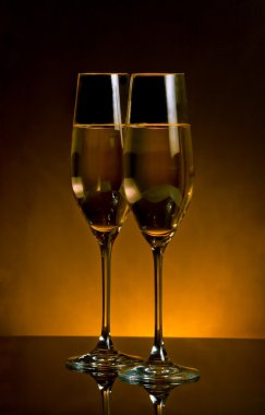 koyu Altın ışık arka plan üzerinde şampanya flüt çifti