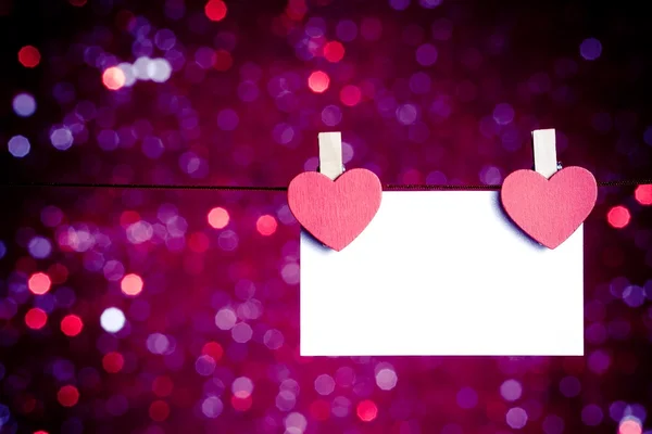 Dos corazones rojos decorativos con tarjeta de felicitación colgando de fondo bokeh luz azul y violeta, concepto de día de San Valentín —  Fotos de Stock