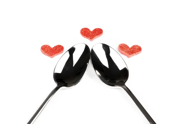 Top of view of decorative red hearts near teaspoons on white background, valentine day dinner on white background — Stock Photo, Image