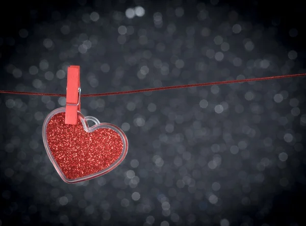 Coeur rouge décoratif suspendu sur fond bokeh clair foncé, concept de Saint Valentin — Photo