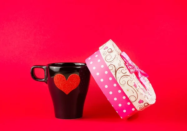 Cup near gift on red background, concept of valentine day — Stock Photo, Image