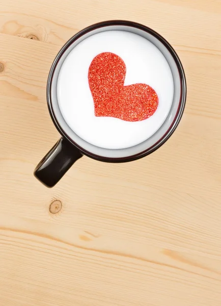 Bovenkant van weergave van kopje melk met decoratieve hart op houten tafel, concept van dag van de Valentijnskaart — Stockfoto