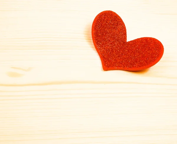 Un corazón rojo decorativo sobre fondo de madera, concepto de día de San Valentín —  Fotos de Stock
