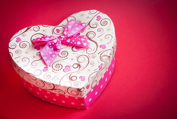 Caja de regalo con cinta sobre fondo rojo, concepto de día de San Valentín —  Fotos de Stock