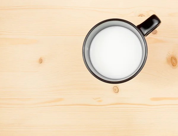 Верхний вид на чашку молока на деревянном столе, концепция завтрака — стоковое фото