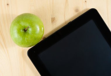 ahşap masa üzerinde dijital tablet pc ve yeşil elma görünümünün üst
