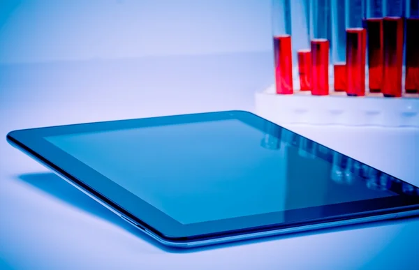 Modern digital tablet pc near test tube in laboratory — Stock Photo, Image