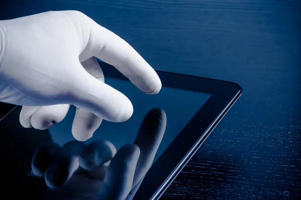 Рука в медицинской перчатке касаясь современного цифрового планшета ПК — стоковое фото