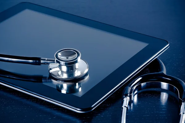 Stetoscopio medico su moderno tablet digitale in laboratorio su tavolo in legno — Foto Stock