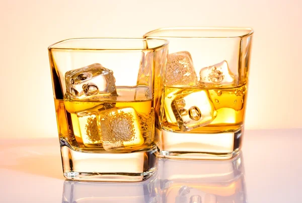 A pair of glasses of whisky with ice — Stock Photo, Image