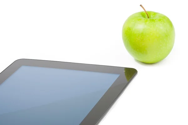 Детали цифровой планшет ПК рядом с зеленым яблоком на белом фоне — стоковое фото