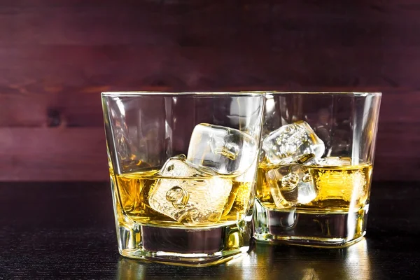 Serisi, eski ahşap masa olarak buzlu viski iki kadeh içki — Stok fotoğraf