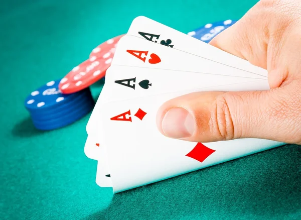 Playing cards in a man hand in front of fiches — Stock Photo, Image