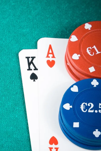 Tarjetas de póquer y fichas de juego en mesa de juego verde — Foto de Stock