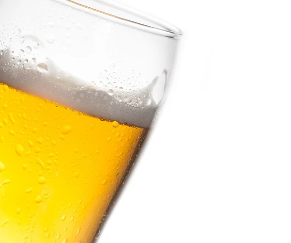Szczegóły przechylony szklankę świeżego piwa z spada na białym tle — Zdjęcie stockowe