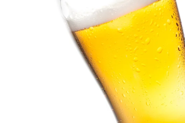 Detail eines gekippten Glases frisches Bier mit Tropfen auf weißem Hintergrund — Stockfoto