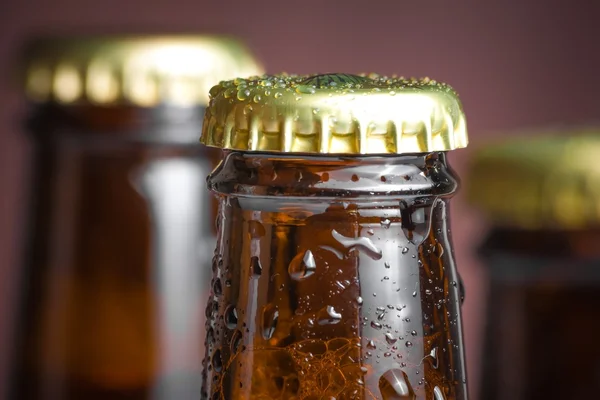 Primer plano de la parte superior de la botella de cerveza fresca con gotas — Foto de Stock