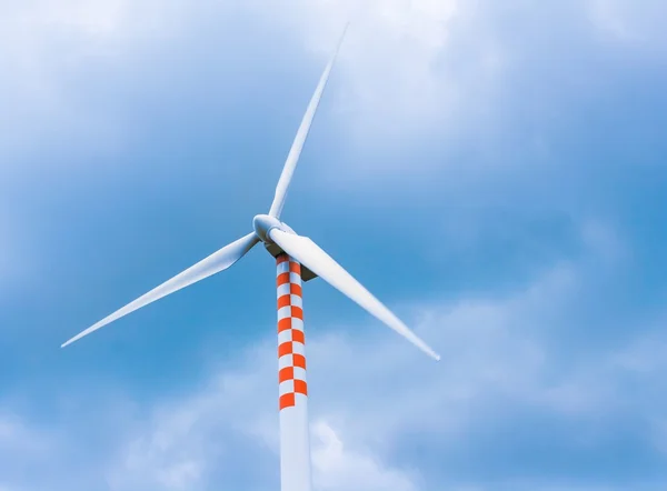 Ветряная турбина в движении под голубым небом и облаками — стоковое фото