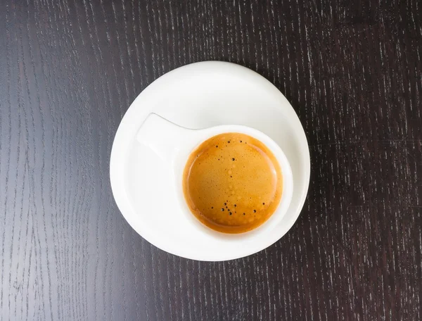 Top of view of great italian coffee in a white cup on black wood table — Stock Photo, Image