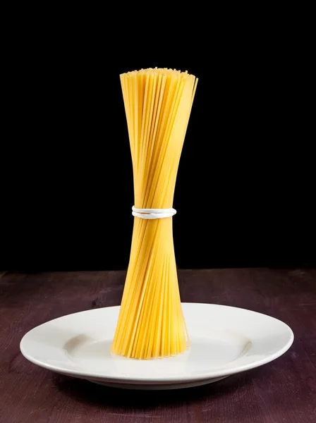 Ruwe pasta spaghetti op vlakke over oude houten tafel met ruimte voor tekst — Stockfoto