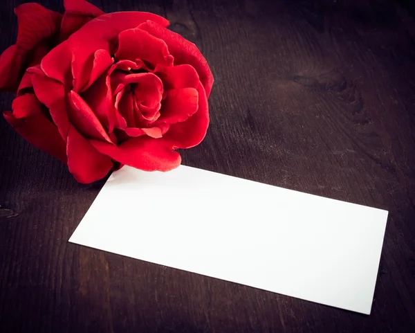 Rosa roja y tarjeta de regalo en blanco para texto sobre fondo de madera vieja — Foto de Stock