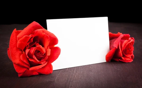 Dwie czerwone róże i puste karty dla tekstu na tle starego drewna — Zdjęcie stockowe