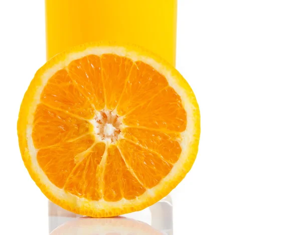 Half orange in front of glass of orange juice on white background — Stock Photo, Image