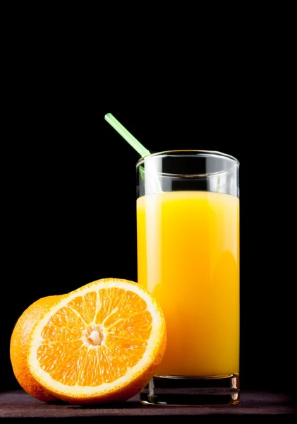 Full glass of orange juice with straw near half orange — Stock Photo, Image