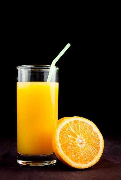 Full glass of orange juice with straw near half orange and space for text — Stock Photo, Image