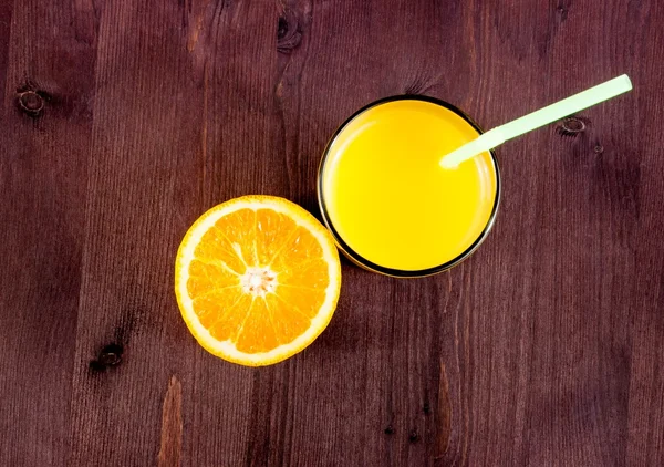 Dessus de la vue du verre plein de jus d'orange avec de la paille et demi-orange avec de l'espace pour le texte — Photo