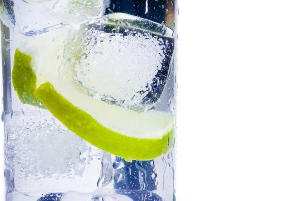 Close-up of cocktail glass with ice and lime slice isolated and space for text — Stock Photo, Image