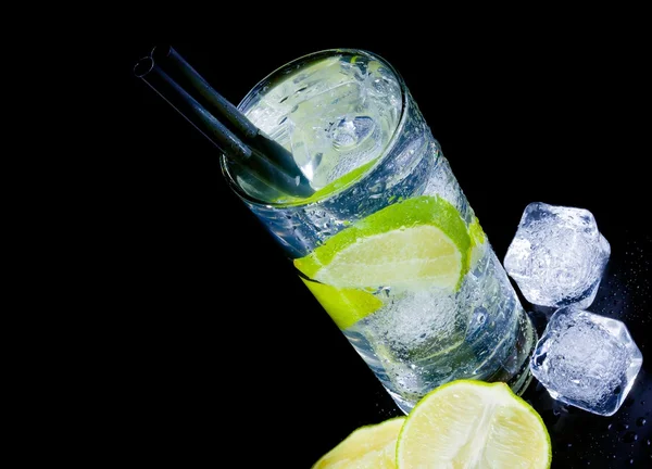 Bovenkant van weergave van cocktail met ijs en kalk segment met stro en ruimte voor tekst — Stockfoto