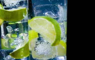 iki kadeh kokteylle close-up ve buz ile metin için yer siyah zemin üzerine kireç dilim